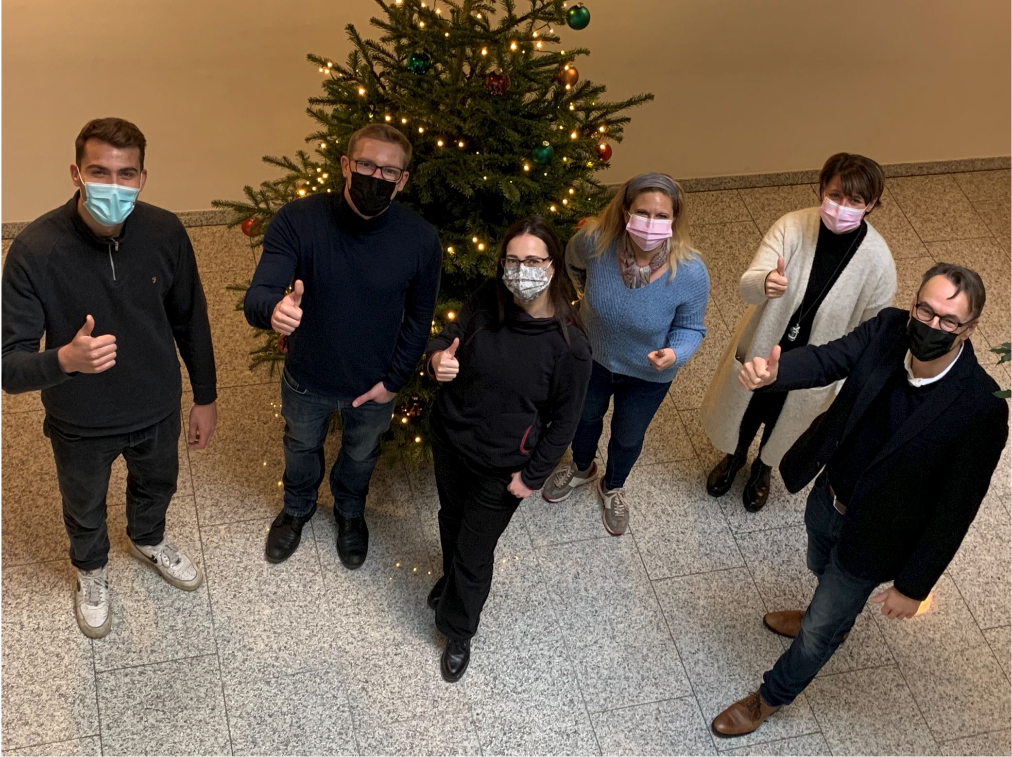 Menschen vor einem Weihnachtsbaum