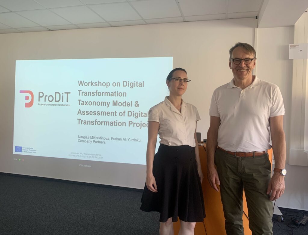 Andreas Franke und Anne Henter stehen vor der Beamerfolie zum ProDiT-Treffen
