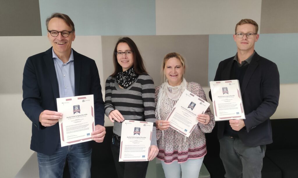 Andreas, Anne, Daniela und Joel zeigen ihre Autorisierungen für den INQA-Coach